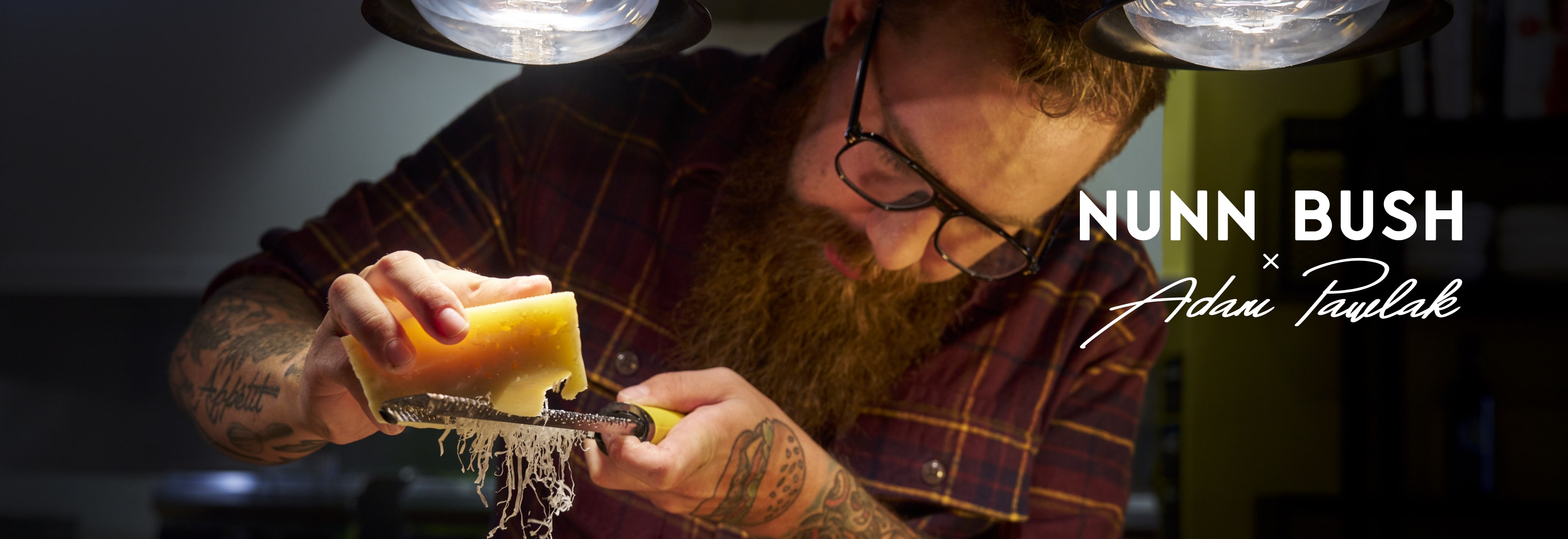 Image features Chef Adam Pawlak grating parmesan cheese. 